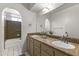 Well-lit bathroom with a double sink vanity, arched doorway, and tile accents creating a warm and inviting space at 4001 E Cannon Dr, Phoenix, AZ 85028