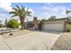 Well-maintained single-story home with desert landscaping, a large palm tree, and a two-car garage at 4001 E Cannon Dr, Phoenix, AZ 85028