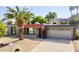 Charming single-story home featuring a desert landscaped yard with a large palm tree and an attached two-car garage at 4001 E Cannon Dr, Phoenix, AZ 85028