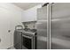 Well-equipped laundry room with modern washer, dryer, stainless steel fridge, and white cabinets for ample storage at 4001 E Cannon Dr, Phoenix, AZ 85028