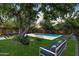 Lush backyard featuring a sparkling pool, comfortable seating, and mature trees at 4216 N 42Nd St, Phoenix, AZ 85018