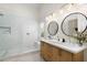 Bright bathroom with double vanity, stylish lighting, and a walk-in shower with bench at 4216 N 42Nd St, Phoenix, AZ 85018