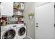 Functional laundry room with washer, dryer, shelving, and patterned tile floor at 42186 W Cribbage Rd, Maricopa, AZ 85138