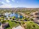 Scenic aerial shot of a Primary-planned community featuring a tranquil lake and a sparkling community pool at 43298 W Delia Blvd, Maricopa, AZ 85138