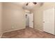 Neutral bedroom showcasing tile flooring, closet, ceiling fan, and access to additional rooms at 43298 W Delia Blvd, Maricopa, AZ 85138