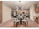 Dining room area illuminated by a modern chandelier, seamlessly flowing into the adjacent kitchen at 43298 W Delia Blvd, Maricopa, AZ 85138