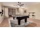 Spacious game room with a pool table covered in black tarp on top of a white rug at 43298 W Delia Blvd, Maricopa, AZ 85138