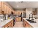 Modern kitchen with stainless steel appliances, light wood cabinetry, and a stylish tile backsplash at 43298 W Delia Blvd, Maricopa, AZ 85138