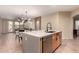 A kitchen island with modern sink and faucet, light countertops and views to the dining and living rooms at 43298 W Delia Blvd, Maricopa, AZ 85138