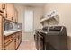 Bright laundry room boasts modern appliances, tile flooring, and ample storage space at 43298 W Delia Blvd, Maricopa, AZ 85138