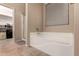 A soaking tub and walk-in shower are featured in this ensuite bathroom at 43298 W Delia Blvd, Maricopa, AZ 85138