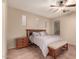 This main bedroom features a ceiling fan and tile flooring, with a bench at the end of the bed at 43298 W Delia Blvd, Maricopa, AZ 85138