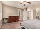 This main bedroom features tile flooring, ceiling fan, dresser, and door to the backyard at 43298 W Delia Blvd, Maricopa, AZ 85138
