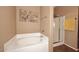 Bathroom with soaking tub, glass enclosed shower, and neutral walls and tile flooring at 45558 W Mountain View Rd, Maricopa, AZ 85139