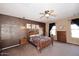 Cozy bedroom with a traditional bed frame, carpet, ceiling fan, and dark curtains at 45558 W Mountain View Rd, Maricopa, AZ 85139