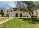 Inviting exterior view of condo with lush lawn, mature shade trees, and path to the unit at 4730 W Northern Ave # 1158, Glendale, AZ 85301