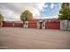 Rustic barn with a red sliding doors and weathered metal siding, set against a backdrop of trees and sky at 51238 N Pinal Ranch Rd, Miami, AZ 85539