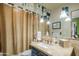 The bathroom features a stone countertop, blue vanity, travertine tile, and a burlap shower curtain at 51238 N Pinal Ranch Rd, Miami, AZ 85539