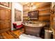 The relaxing bathroom has a copper soaking tub, wood accents and floors, and a red velvet bench at 51238 N Pinal Ranch Rd, Miami, AZ 85539