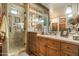Rustic bathroom features a stone shower, wood cabinetry, granite countertops, and custom fixtures at 51238 N Pinal Ranch Rd, Miami, AZ 85539