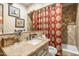 The bathroom has a tile shower, patterned curtain, tan walls, and a light granite countertop at 51238 N Pinal Ranch Rd, Miami, AZ 85539