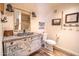 Rustic bathroom featuring unique vanity with ample storage space and decorative mirror, blending rustic charm at 51238 N Pinal Ranch Rd, Miami, AZ 85539