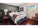 Bright bedroom with a designer metal bed frame and wooden floors, illuminated by natural light at 51238 N Pinal Ranch Rd, Miami, AZ 85539
