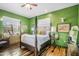 Spacious bedroom with a four-poster bed, green walls, wood floors, and two large windows at 51238 N Pinal Ranch Rd, Miami, AZ 85539
