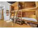 Unique bunk room featuring wood paneled walls, sleeping for eight, ladders for access and adjacent bathroom at 51238 N Pinal Ranch Rd, Miami, AZ 85539