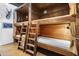 Unique bunk room featuring wood paneled walls, sleeping for eight, ladders for access and adjacent bathroom at 51238 N Pinal Ranch Rd, Miami, AZ 85539