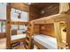 Cozy bunk room featuring wood paneled walls, sleeping for four, ladders for access and adjacent bathroom at 51238 N Pinal Ranch Rd, Miami, AZ 85539