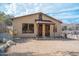 Charming home featuring a quaint covered porch and unique architectural details on a gravel lot with natural rock outcroppings at 51238 N Pinal Ranch Rd, Miami, AZ 85539