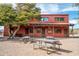 Hotel exterior showcasing a charming picnic area with gravel, metal siding, wooden doors and rustic architecture at 51238 N Pinal Ranch Rd, Miami, AZ 85539