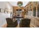 Home office with exposed brick, a large desk, built-in shelving, and natural light at 51238 N Pinal Ranch Rd, Miami, AZ 85539