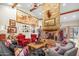 Spacious living room featuring stone fireplace, beamed ceilings, wood floors, and designer furnishings at 51238 N Pinal Ranch Rd, Miami, AZ 85539