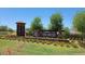The Tierra Montana community entrance features an attractive stone monument, manicured landscaping, and welcoming signage at 5206 W Top Hand Trl, Laveen, AZ 85339
