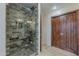 Bathroom shower stall featuring glass doors and stone tile at 8110 N 18Th Pl, Phoenix, AZ 85020