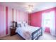 Stylish bedroom featuring pink striped walls, ceiling fan, and comfortable bed with accent pillows at 896 E Dragon Fly Rd, San Tan Valley, AZ 85143