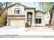 Two-story home with a two-car garage, arched entryway, desert landscaping, and covered front porch at 896 E Dragon Fly Rd, San Tan Valley, AZ 85143