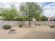 Backyard featuring neutral landscaping, a stone fire pit, and a block wall fence for privacy at 9612 W Mariposa Grande --, Peoria, AZ 85383