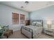 Cozy bedroom featuring a metal bed frame, neutral walls, a dark wood dresser and natural light streaming through the window at 9612 W Mariposa Grande --, Peoria, AZ 85383
