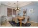 Charming dining area featuring a wooden table, upholstered chairs, and a contemporary light fixture at 9612 W Mariposa Grande --, Peoria, AZ 85383