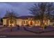 Attractive single-story home featuring a stone facade and desert landscape, softly illuminated in the evening twilight at 9612 W Mariposa Grande --, Peoria, AZ 85383