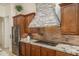 Modern kitchen featuring stainless steel appliances, granite countertops, a custom stone range hood and tile backsplash at 9612 W Mariposa Grande --, Peoria, AZ 85383
