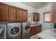 Laundry room with side-by-side washer and dryer, wood cabinets, granite countertops, and a utility sink at 9612 W Mariposa Grande --, Peoria, AZ 85383