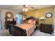 Charming bedroom featuring a decorative mirror, a large bed with colorful bedding, and stylish lamps at 9814 W Shasta Dr, Sun City, AZ 85351