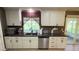 Modern kitchen with stainless steel appliances, dark countertops, and ample white cabinet storage at 9814 W Shasta Dr, Sun City, AZ 85351