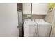 Functional laundry room featuring a washer, dryer, water heater, and upper cabinets at 9814 W Shasta Dr, Sun City, AZ 85351