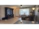 Cozy living room with neutral walls, large window with patterned curtains, and entertainment center at 9814 W Shasta Dr, Sun City, AZ 85351