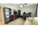 Spacious office with dark wood furniture, including shelving, drawers and an entertainment center at 9814 W Shasta Dr, Sun City, AZ 85351